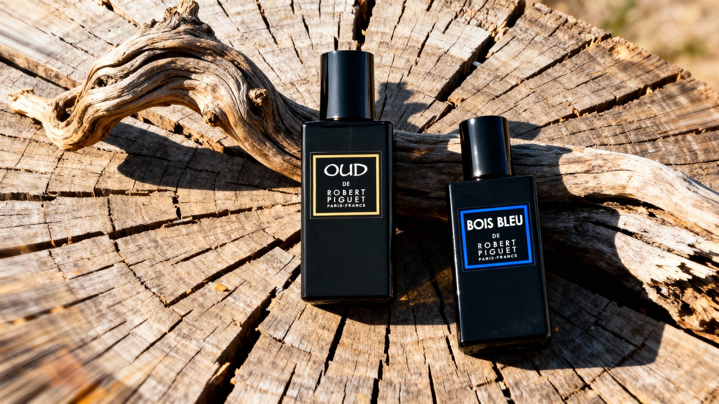 OUD and Bois Bleu perfume bottles on a wooden background