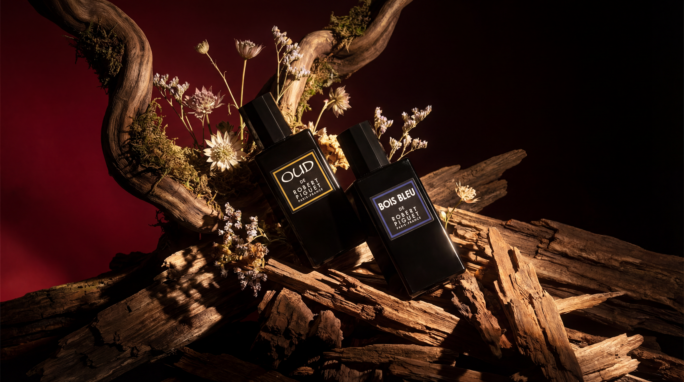 OUD and Bois Bleu perfume bottles on a wooden background