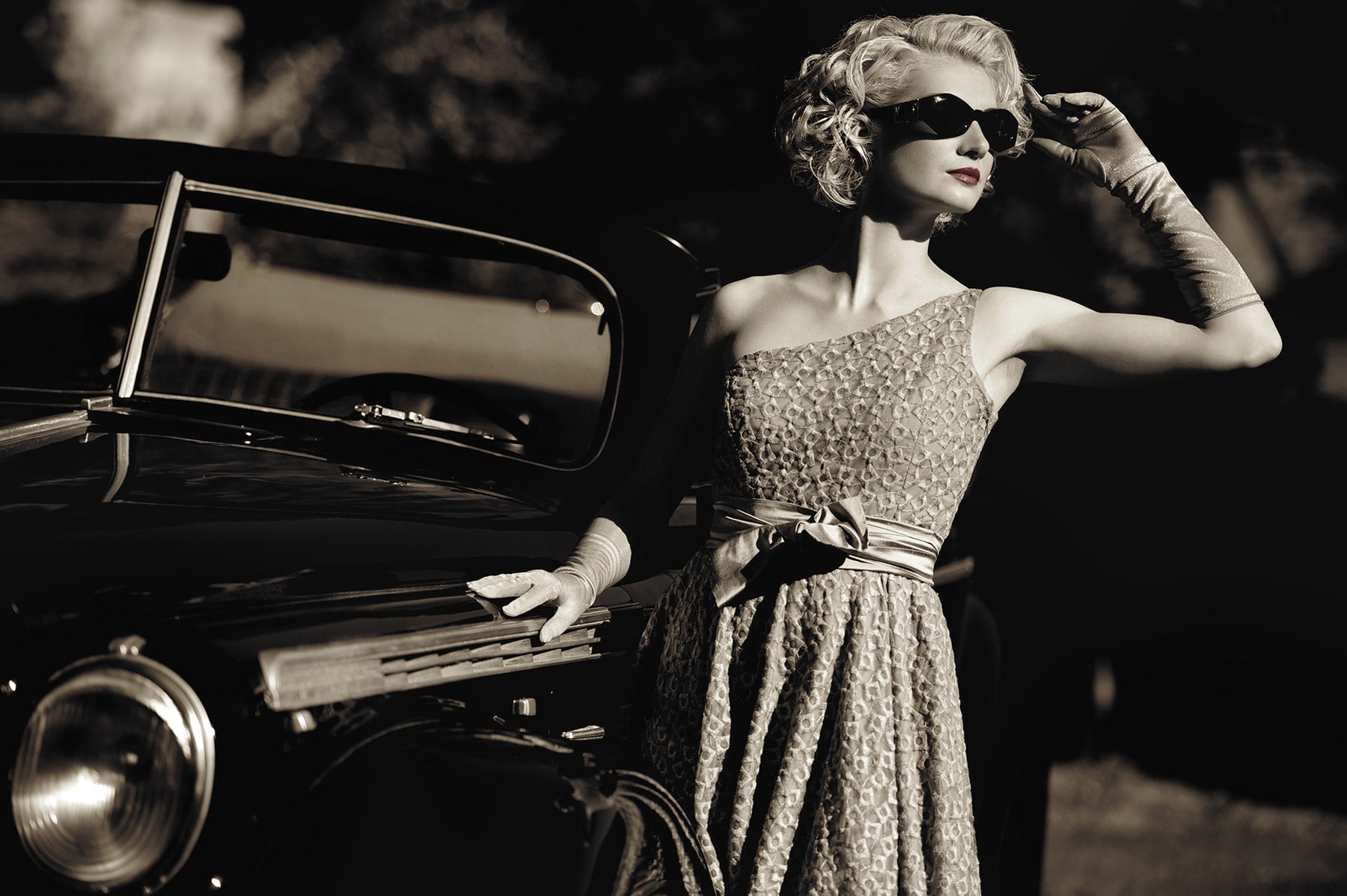 Lady with sunglasses by vintage car